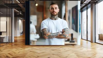 A man with tattoos on both arms is wearing a white t-shirt. Wall mural