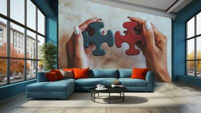 A person holds up two puzzle pieces, a blue one in the left hand and a red one in the right. Wall mural