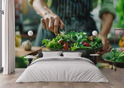 A person in an apron stirs a salad in a bowl. Wall mural