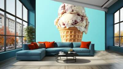 A waffle cone filled with two scoops of melting ice cream against a blue background. Wall mural