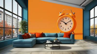 An orange alarm clock on an orange background. Wall mural