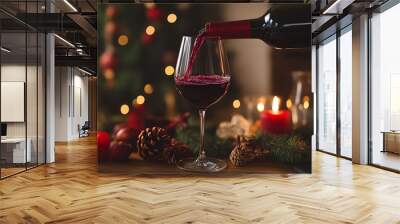 Red wine being poured into a glass with a Christmas background. Wall mural