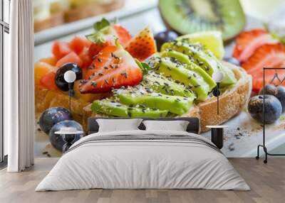 Two slices of avocado toast topped with fruit and seeds. Wall mural