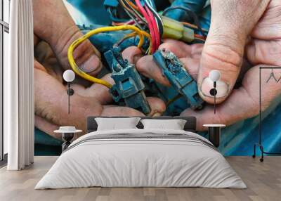 Short circuit in car. Male electrician holding a charred wires. Vehicle repair, car service station Wall mural