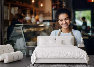 Attractive young woman at the counter in a coffee shop smiles affably and looks at the camera Wall mural