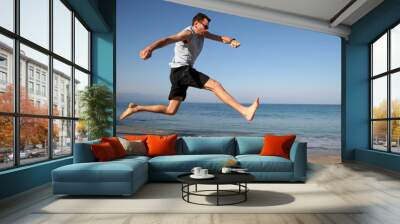 man jumping on the beach Wall mural