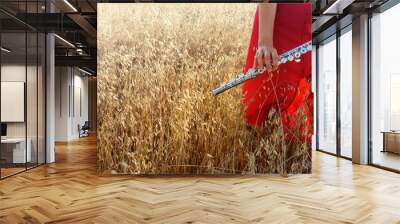 lady in a red dress with a flute on a wheat field Wall mural