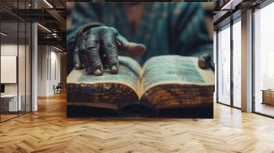 of close-up of a black anonymous person hands gently turning the pages of an open book on table with a warm light overhead Wall mural