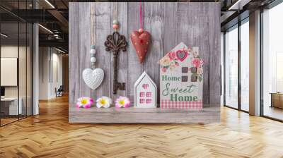 The model of a wooden miniature house is decorated with a decorative heart and a vintage key. Buying or renting a home. Home decor. Sweet home. Grey background. Wall mural