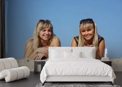 two young women lie on a beach Wall mural