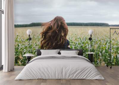 Beautiful carefree long hair asian girl in knitted sweater from behind in the autumn corn field. Sensitivity to nature concept Wall mural