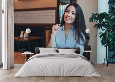 Beautiful charming brunette smiling Asian girl has Breakfast with coffee and Chia pudding at cafe Wall mural