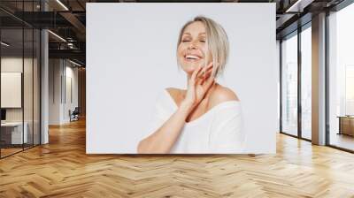 Beauty portrait of blonde smiling laughing woman 35 year plus clean fresh face with close eyes isolated on white background Wall mural