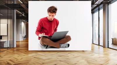 Teenager student with working at laptop and tablet on white background Wall mural