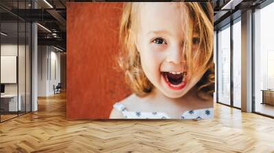 Portrait of an emotional girl on a red background. Wall mural