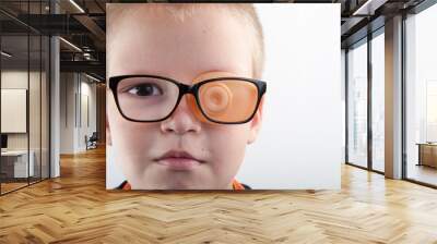 Child in glases with Occluder. Ortopad Boys Eye Patces nozzle for glasses for treating strabismus (lazy eye) Wall mural