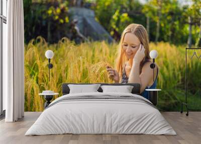 A woman and a ripe harvest of rice. Rice porridge, rice flakes, rice flour Wall mural