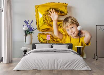 Happy little kid boy celebrating his birthday and blowing candles on homemade baked cake, indoor. Birthday party for children. Carefree childhood, anniversary, happiness. Five years old Wall mural