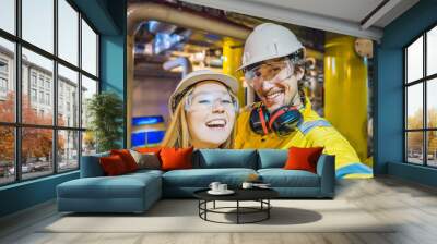 Man and woman in a yellow work uniform, glasses, and helmet in an industrial environment, oil Platform or liquefied gas plant Wall mural