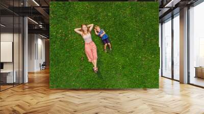 Mom and son are lying on the grass in the park, photos from the drone, quadracopter BANNER long format Wall mural