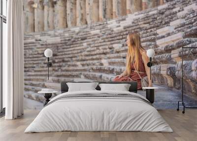 Woman tourist explores Aspendos Ancient City. Aspendos acropolis city ruins, cisterns, aqueducts and old temple. Aspendos Antalya Turkey. turkiye Wall mural