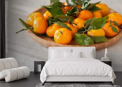 Plate of fresh and juicy tangerines with leaves on a white stone background. Close up and copy space. Wall mural