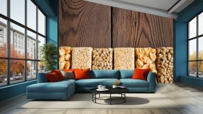 Snacks  - mix of energy bars with peanut, sesame and sunflower seeds on a wooden background Wall mural