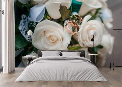 White wedding bouquey of roses and pair of wedding rings on it Wall mural