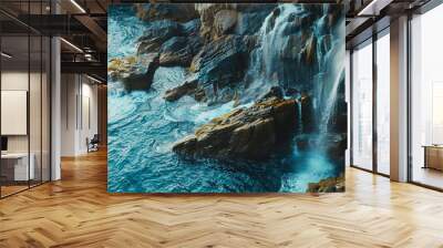 A aerial view of the blue ocean and rocks with waterfall Wall mural