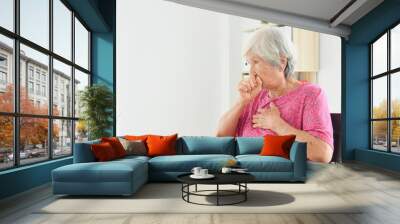 Asian senior woman coughing while sitting on wheelchair Wall mural