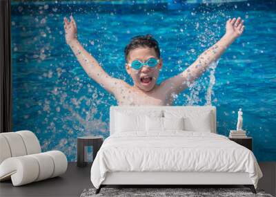 Happy asian boy having fun splashing in swimming pool Wall mural