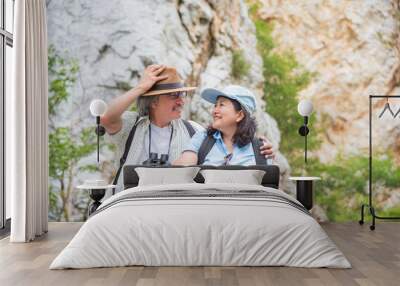 Retired asian couple sitting on the hill and smile together Wall mural