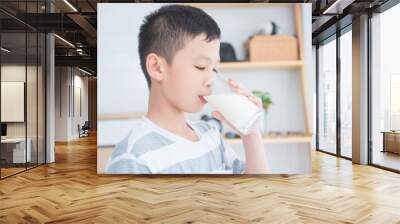 Young asian boy drinking a glass of milk for breakfast Wall mural