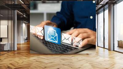 New email notification alerts concept for Digital marketing business communication through virtual inbox and internet technology as Business people use laptop with emails on a virtual screen Wall mural