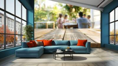 A close up of an empty wooden table with people sitting at tables in the background, a family gathering around for dinner outside on a sunny day, trending photo of an outdoor cafe. Wall mural