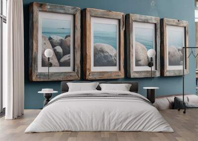 A set of four rustic wooden picture frames with weathered edges, each holding an A4-sized photo, mounted on the wall above a leather sofa in a modern living room with blue walls and natural lighting. Wall mural