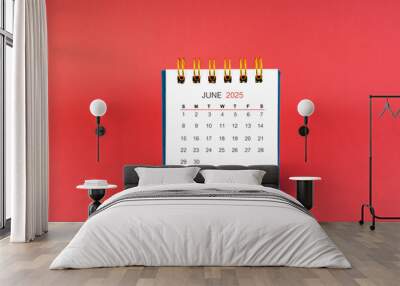 June 2025 white desk calendar on red background. Wall mural