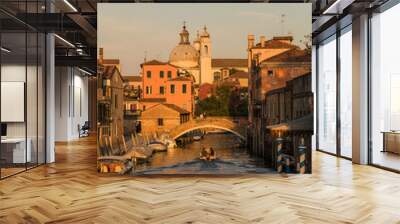 architectural detail of an old bridge in Venice, Italy over a canal and typical architecture on the background and boat passing by  Wall mural