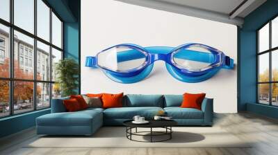 A pair of blue swim goggles with clear lenses, isolated on a white background Wall mural