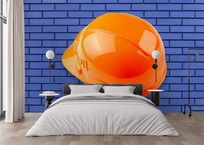 Protective hard hat isolated on blue bricks background. Zine industrial concept. Wall mural