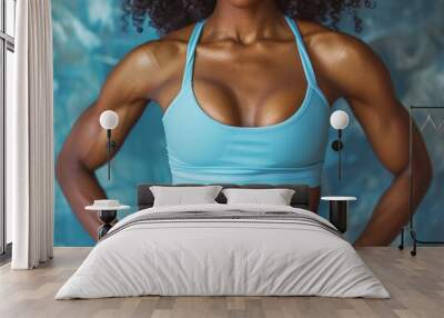 Modella di fitness femminile afroamericana in top blu chiaro e muscoli addominali ben definiti, sfondo tono su tono, azzurro,  sport Wall mural