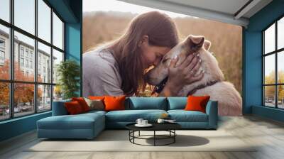 Girl and her friend dog on the straw field background. Beautiful young woman relaxed and carefree enjoying a summer sunset with her lovely dog Wall mural