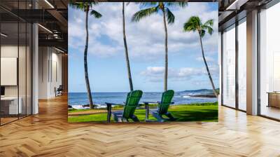 Two rocking chairs under palm trees facing the ocean Wall mural