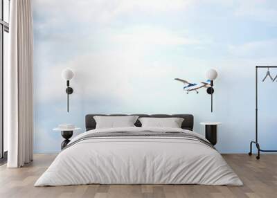 Light plane flying over a little cloudy blue sky Wall mural