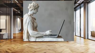 An antique ancient Greek statue working on a laptop in a stylish office. casual attire. Carved from white marble. isolated on background Wall mural