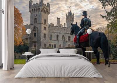 Horseman wearing traditional clothes looking at a castle in autumn Wall mural