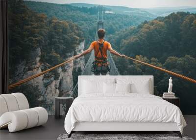 Young adventurer walking on a rope bridge over a forest Wall mural