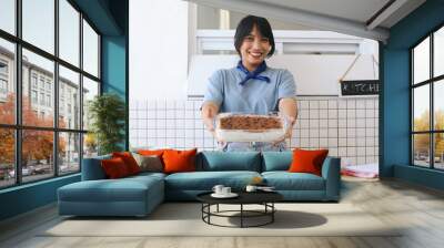 Happy Asian Woman Showing The Homemade Delicious Tiramisu Cake At Kitchen Wall mural