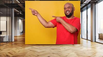 Young Asian fat man wearing casual clothes with a big smile on face, pointing with finger to the side. Wall mural