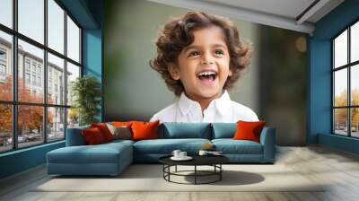 Studio portrait of cute little laughing boy on different colour background Wall mural